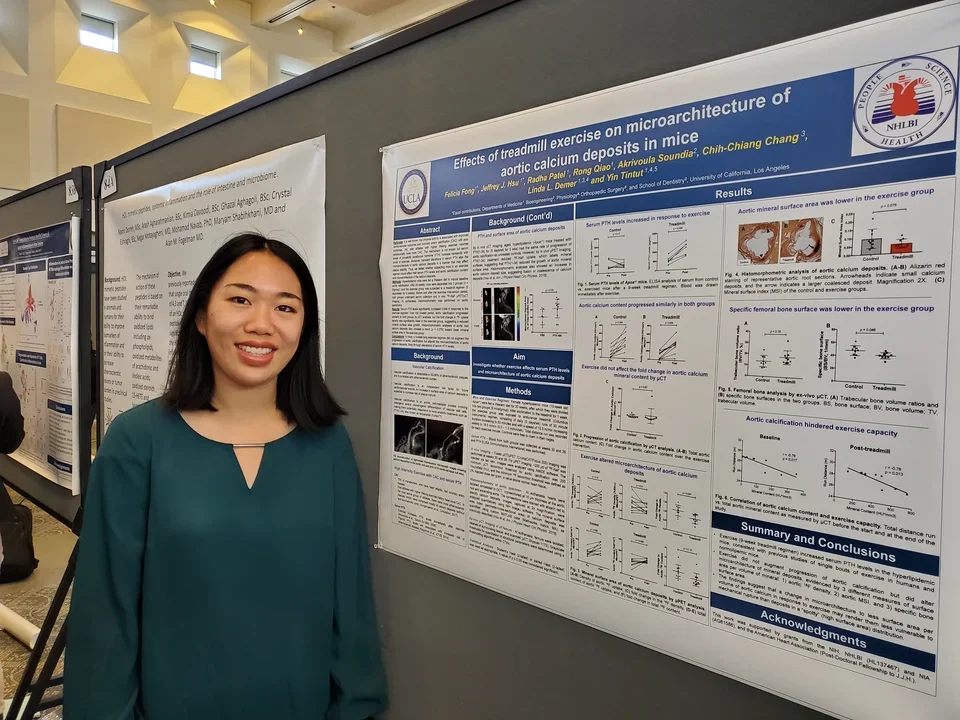 A lab member stands in front of their poster at the UCLA DOM Research Day.