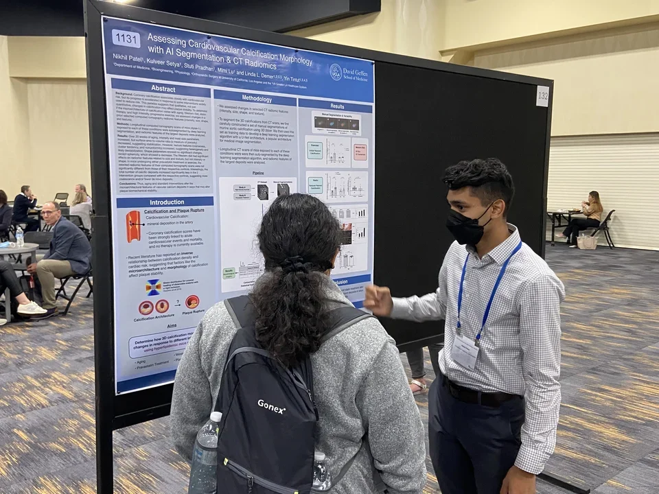 A lab member wearing mask explaining his poster.