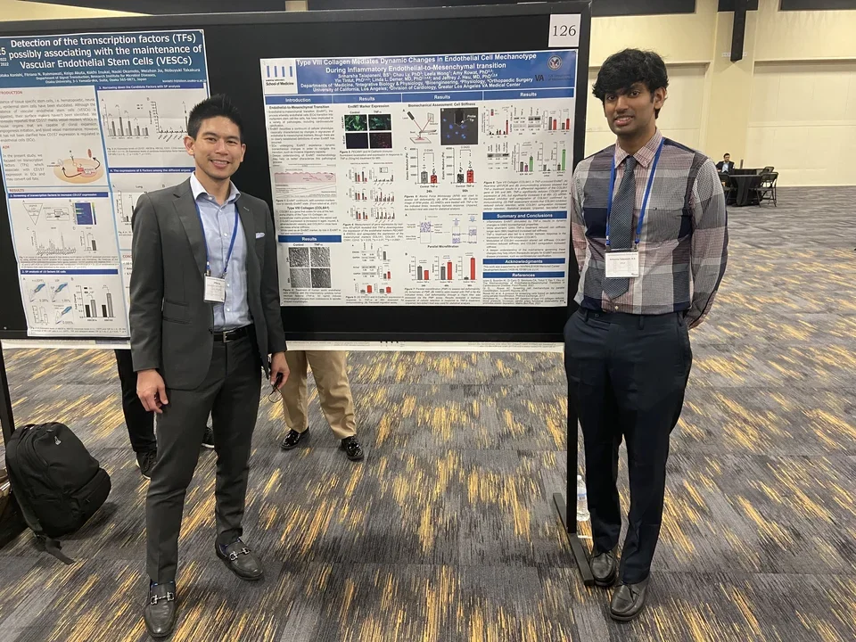 Male lab members standing in front of a poster at the NAVBO/IVBM Meeting in Oakland, CA.