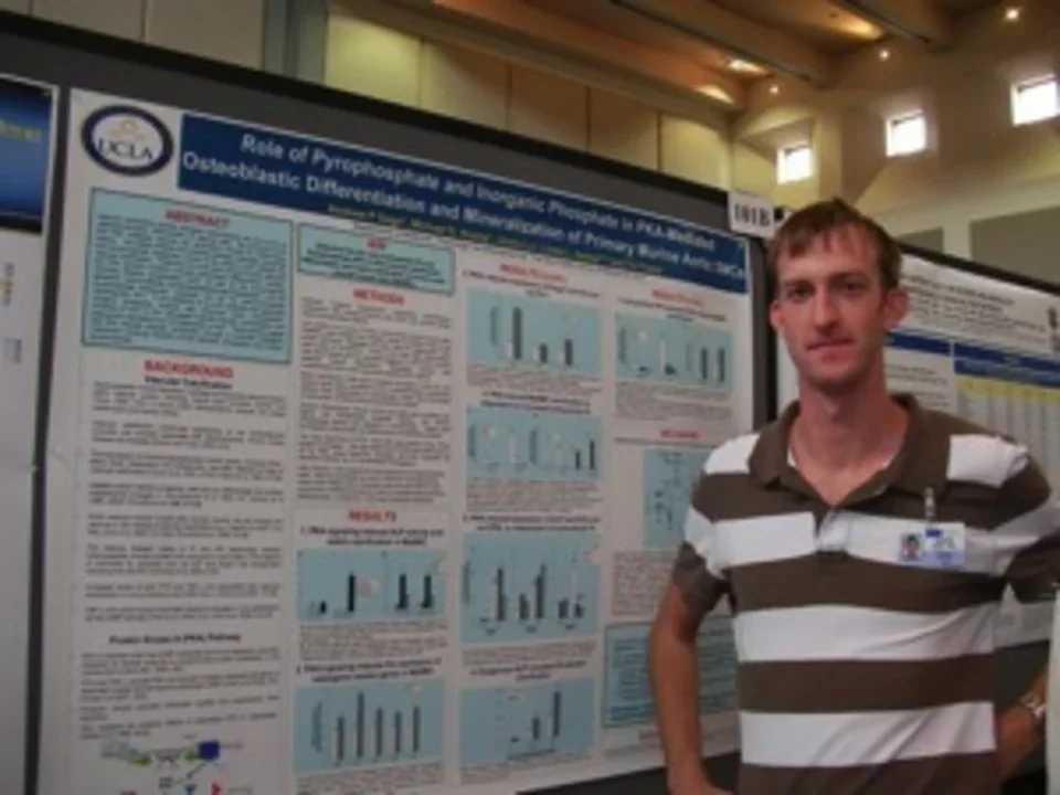 Lab member Andy standing in front of a research poster.
