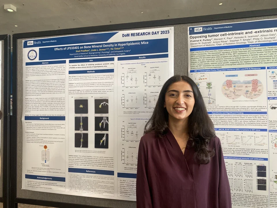 A lab member stands in front of their poster at UCLA DOM Research Day.